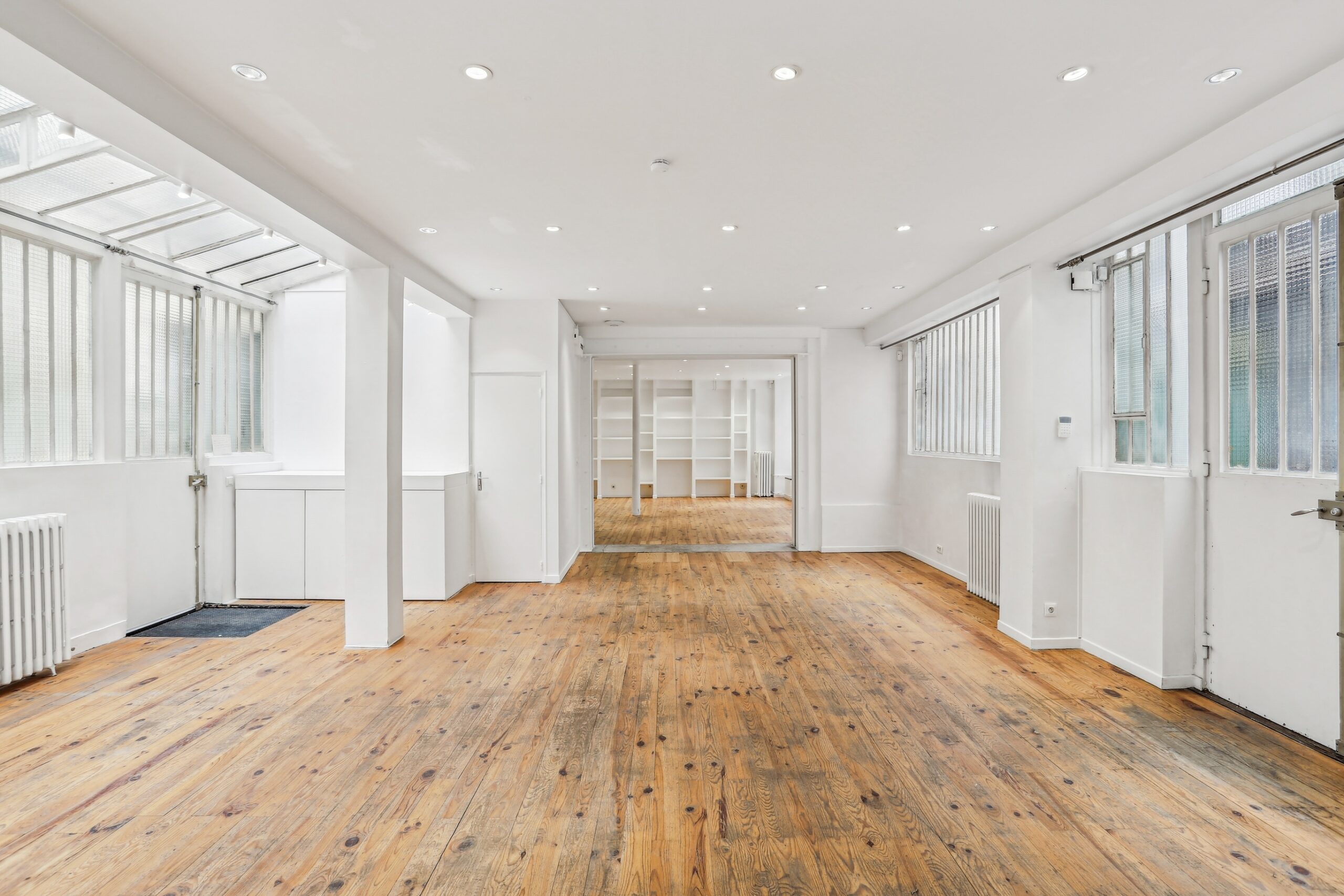 Open plan showroom with long axis and workshop glazing, Marais Paris venue