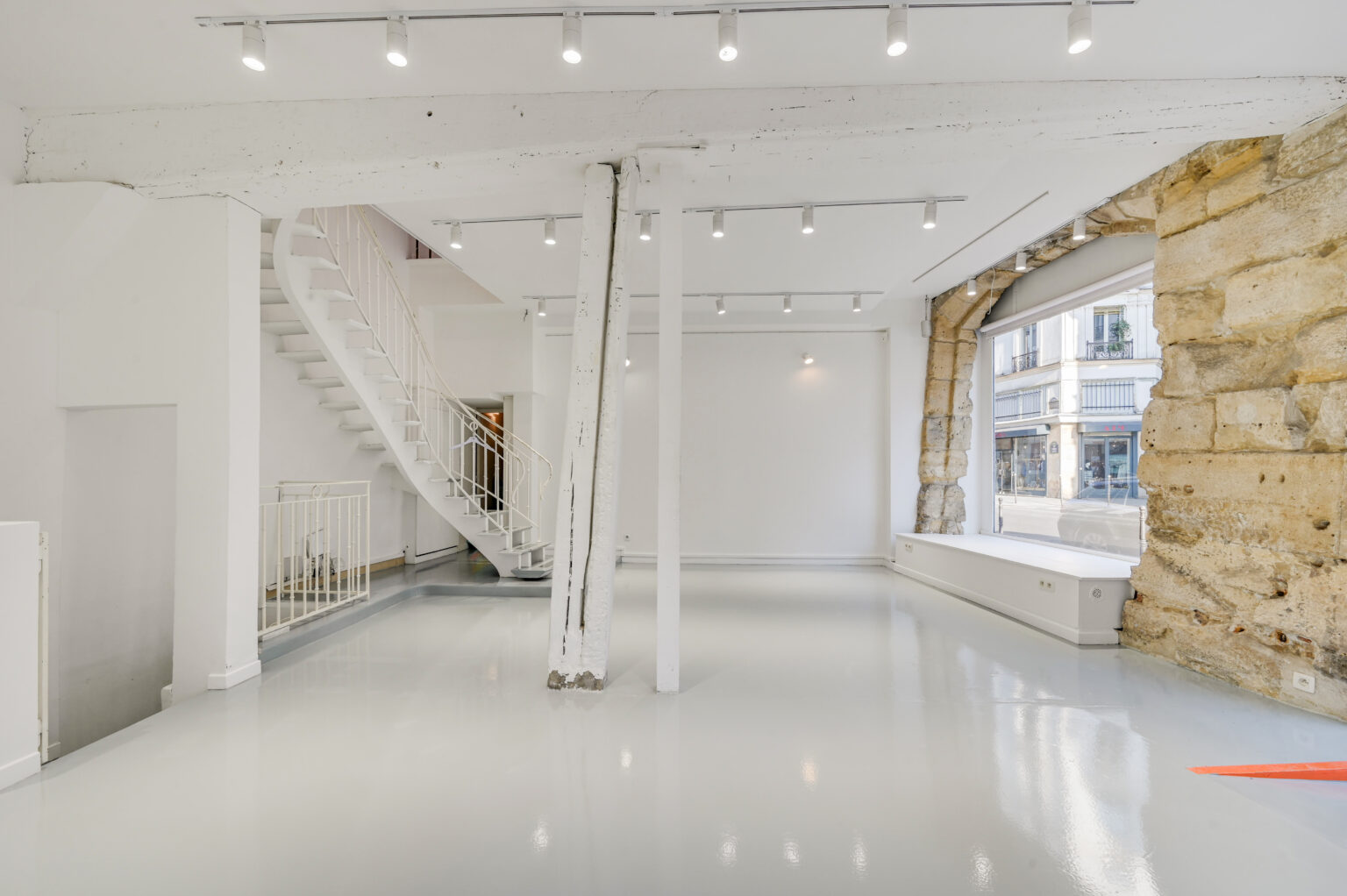 Ground floor showroom showing depth, lighting rails, and large window at 97 Rue de Turenne, Le Marais