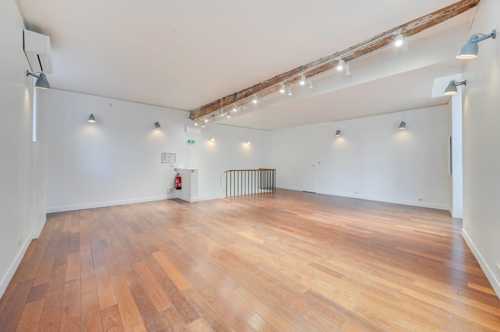 First floor showroom alternate view with wood floors and windows at 97 Rue de Turenne, Le Marais, Paris