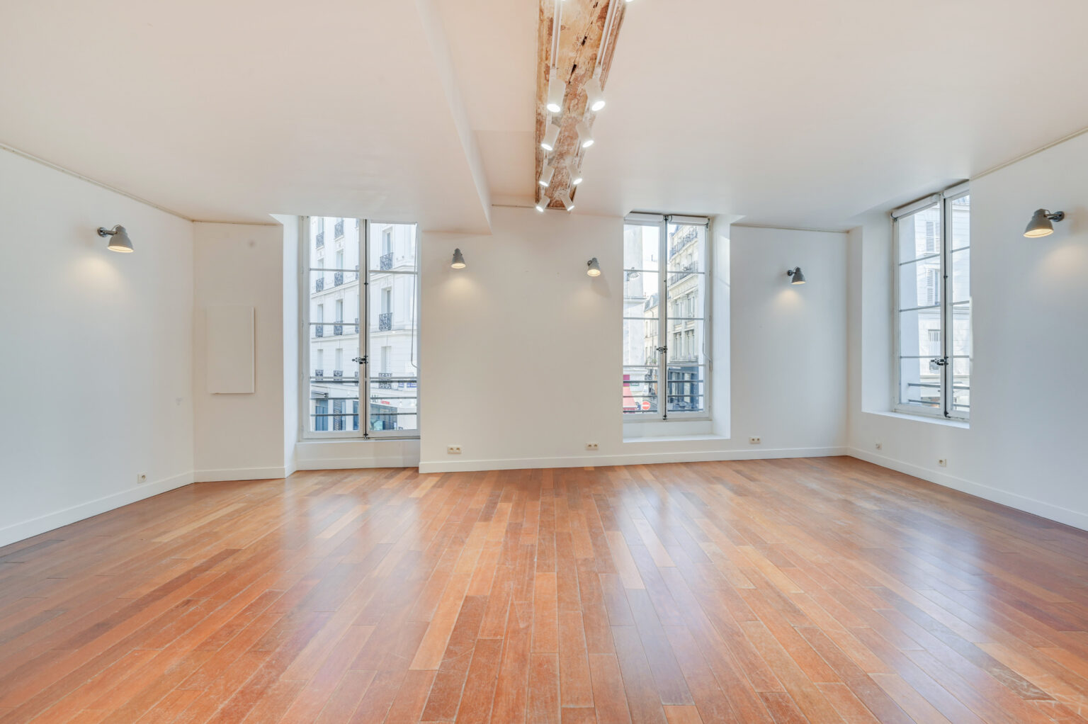 First floor showroom with three tall windows and wood floors at 97 Rue de Turenne, Le Marais
