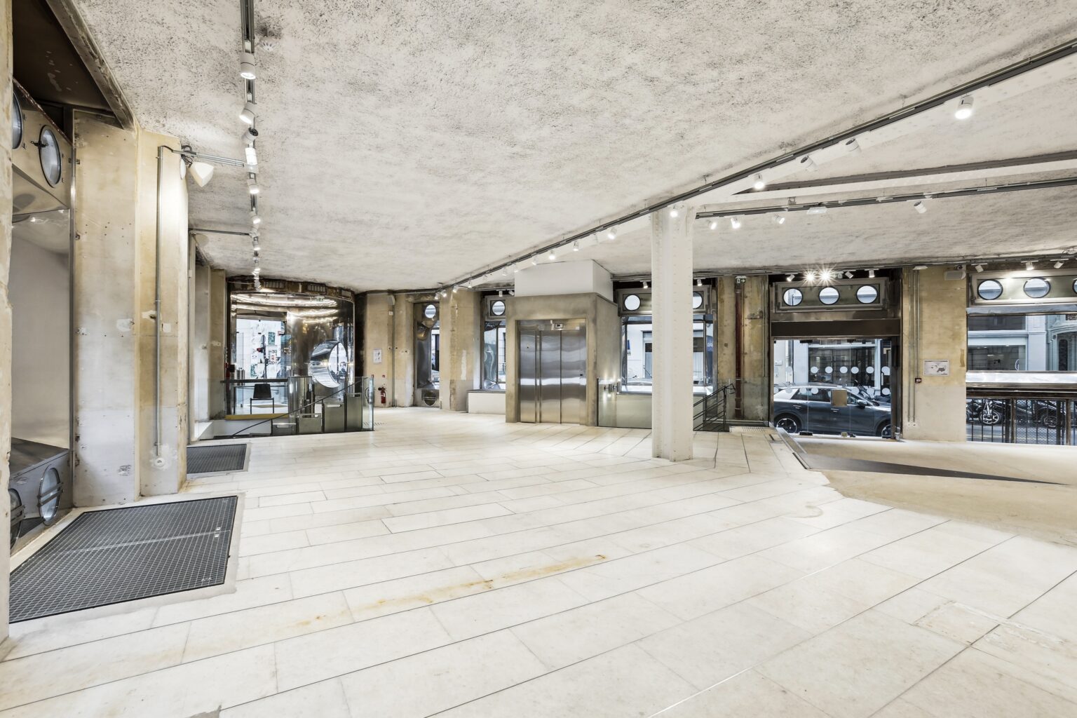 Rear area of Espace Reaumur with exposed brick wall, white volumes, and gallery lighting