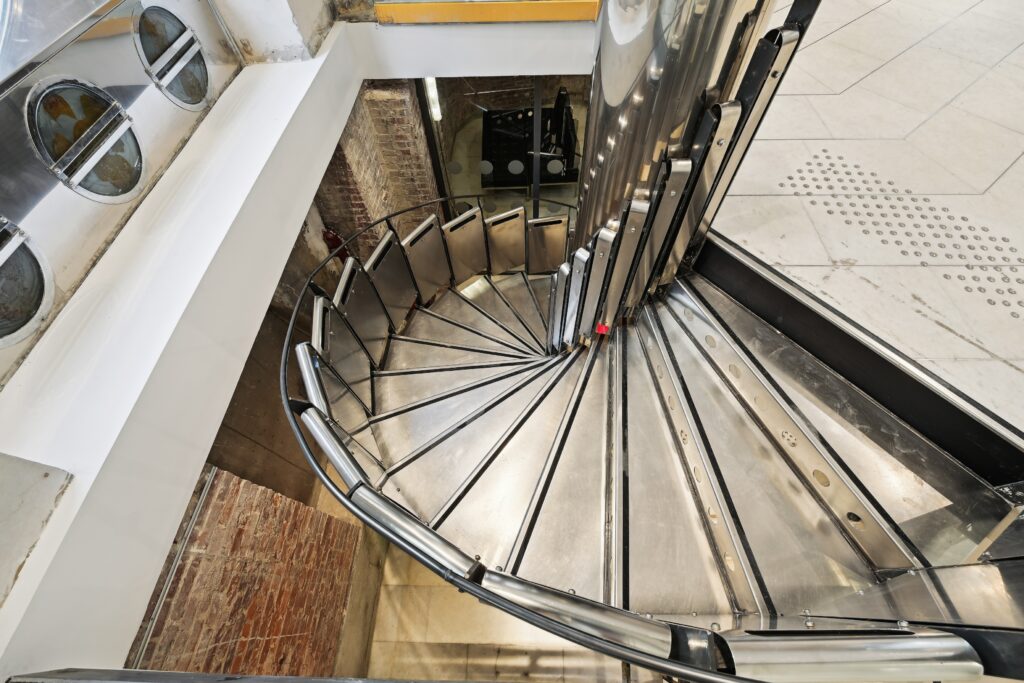 Close-up view of the metal spiral staircase at Espace Reaumur with industrial detailing