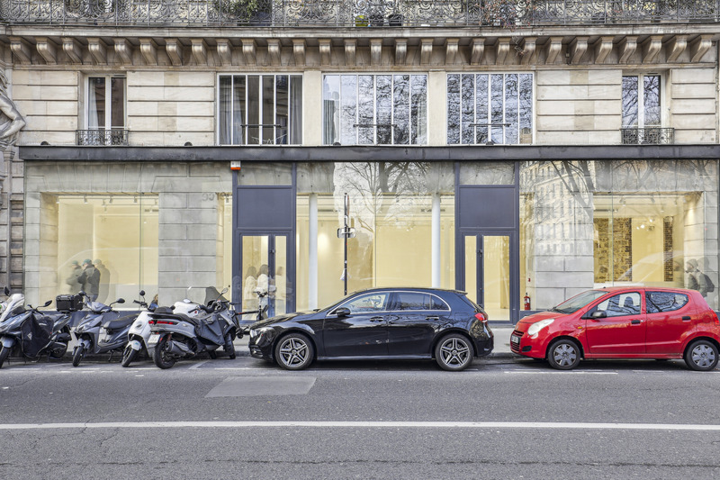 Full building frontage with the showroom windows and two entrances seen from across the street.