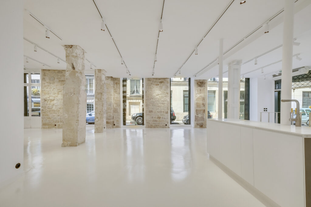 Showroom interior with large windows and stone columns, 62 Rue Charlot Paris