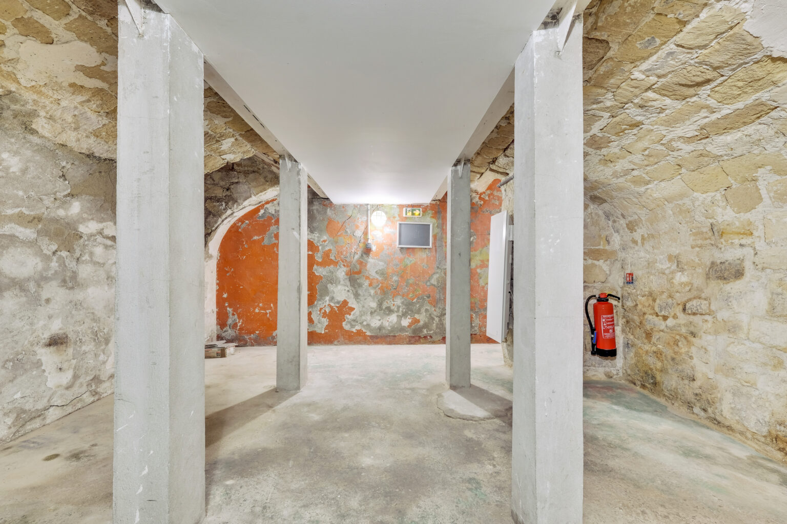 Basement storage area with stone walls at 62 Rue Charlot showroom