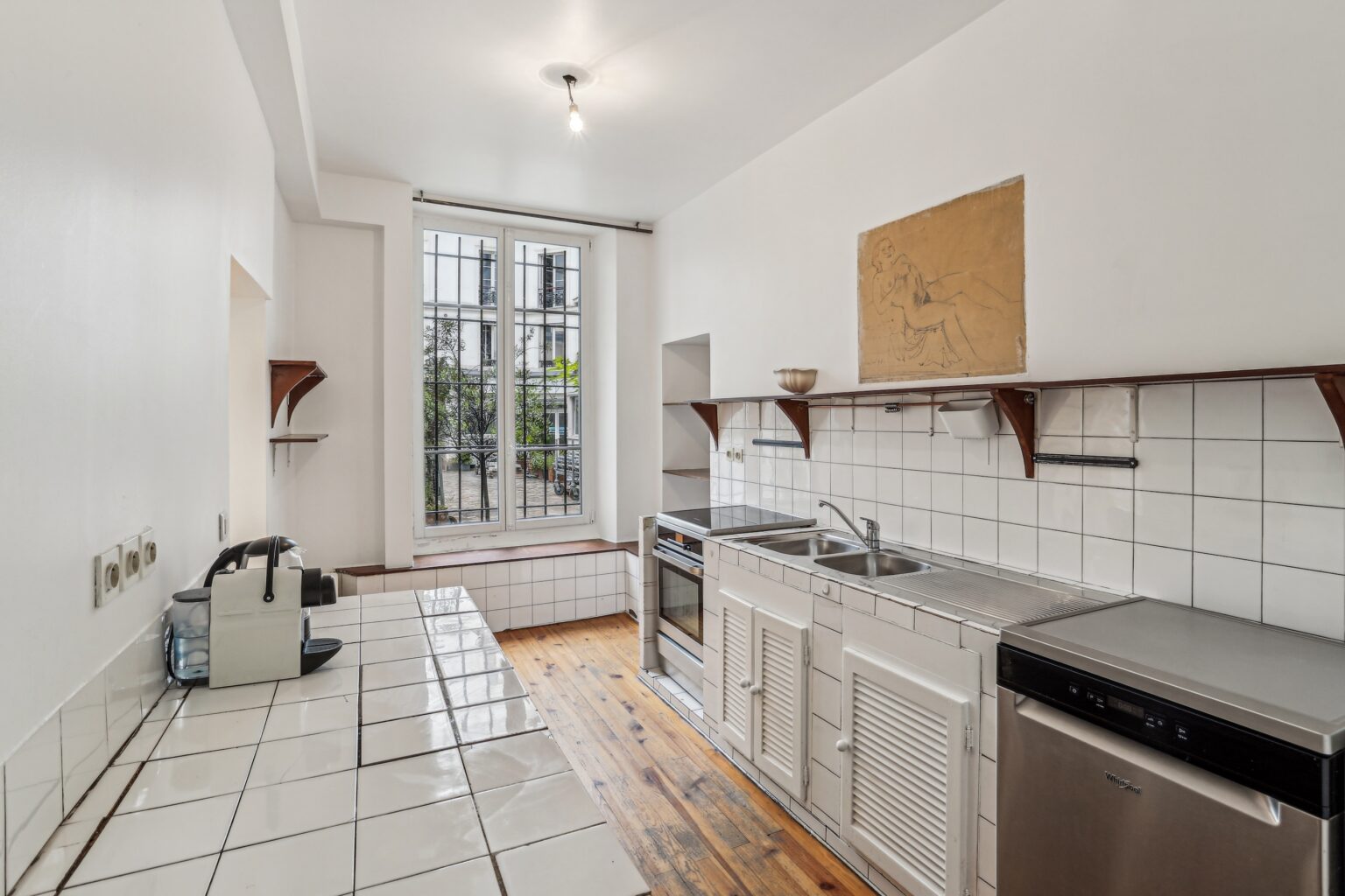 Kitchen space with tiled counters and appliances.