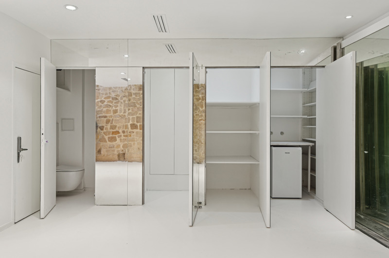 Gallery interior with exposed stone wall and wooden beams Turenne