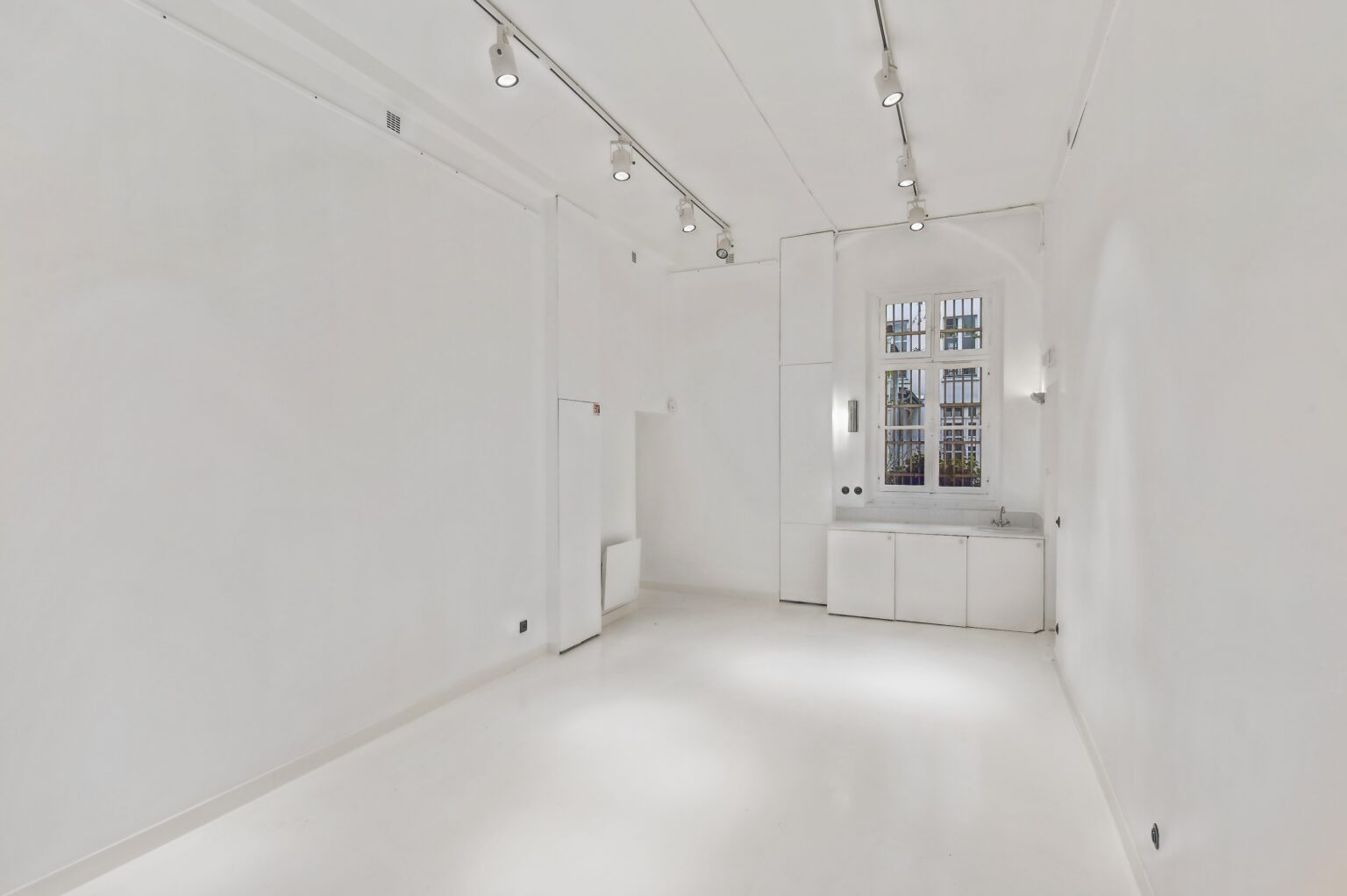 Main showroom space with white floors at 52 Rue Charlot