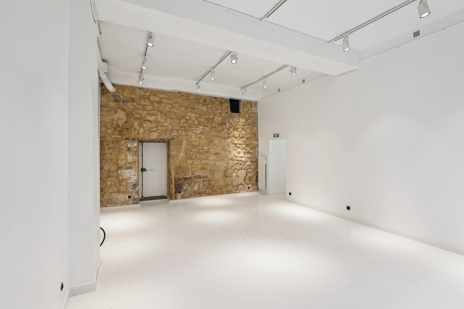 Gallery space with exposed stone wall at 52 Rue Charlot Paris