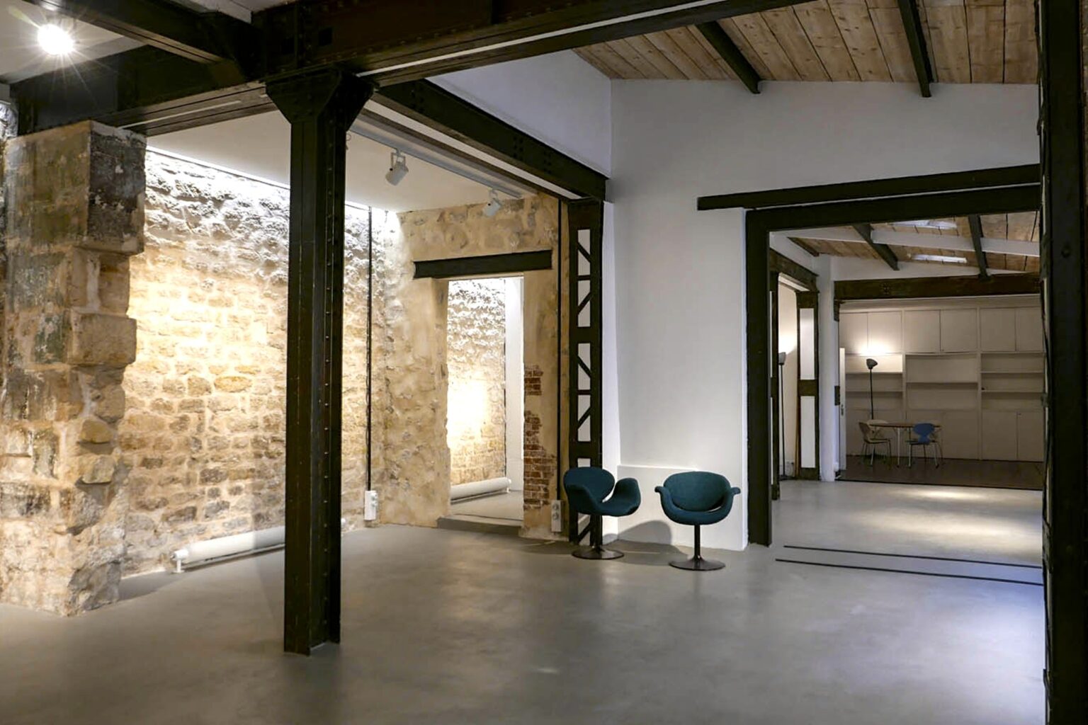 Exposed stone wall showroom interior Paris Marais