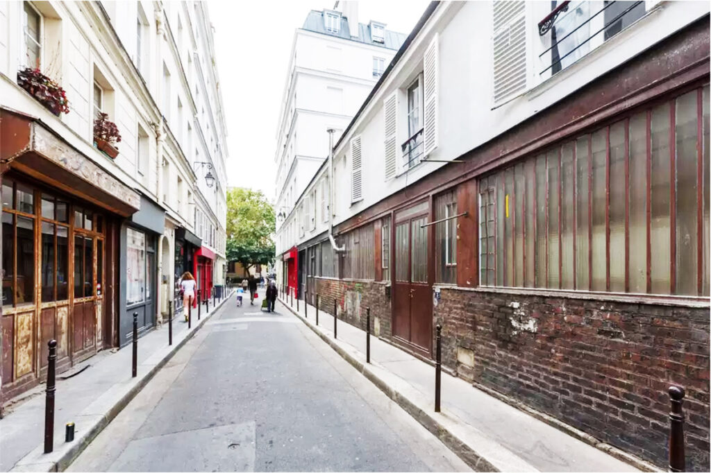 Street view of Rue Dupetit-Thouars in Le Marais, Paris, with storefronts and pedestrian access.