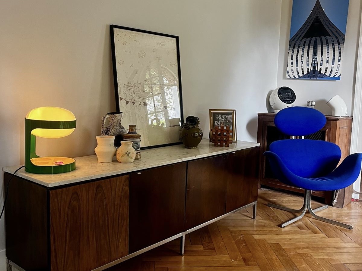 Bedroom interior at Villa Paul Strauss with wooden desk, mirror, table lamp and blue chair.