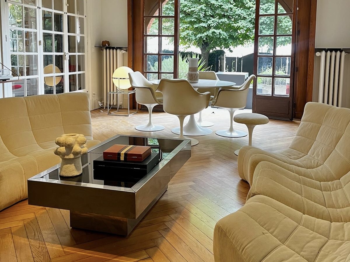 Living room at Villa Paul Strauss with sofas, coffee table and open view onto the garden.