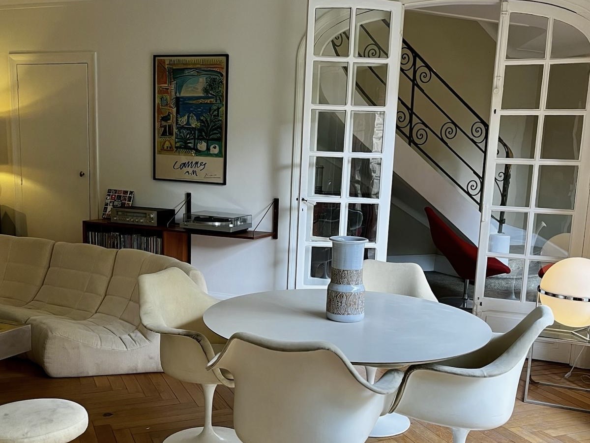 Living room at Villa Paul Strauss with open double doors, seating area and staircase in the background.