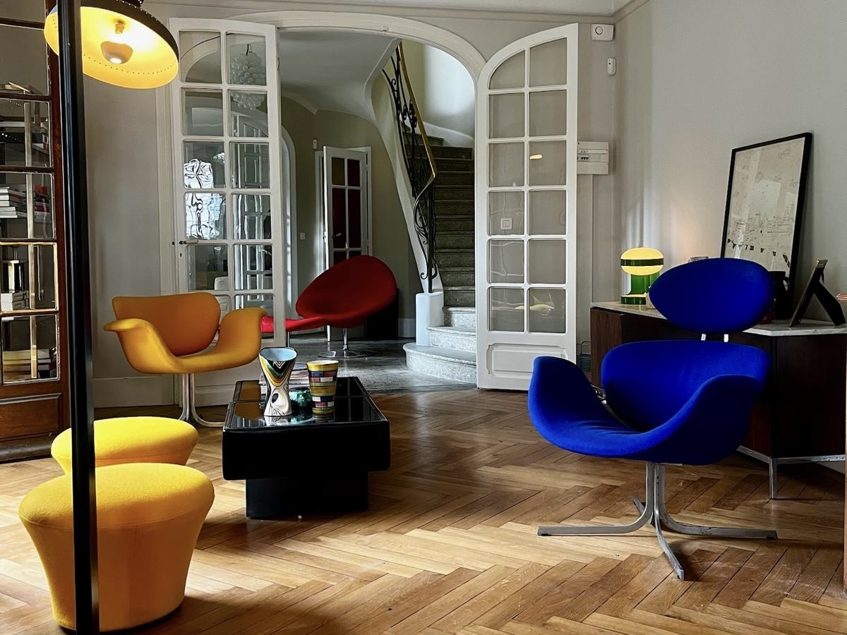 Lounge at Villa Paul Strauss with colorful chairs, parquet flooring and open interior layout.