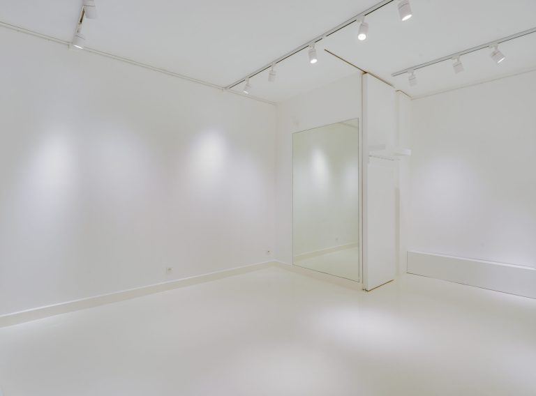 Angled view of main gallery room with seating nook — 43 Rue Charlot