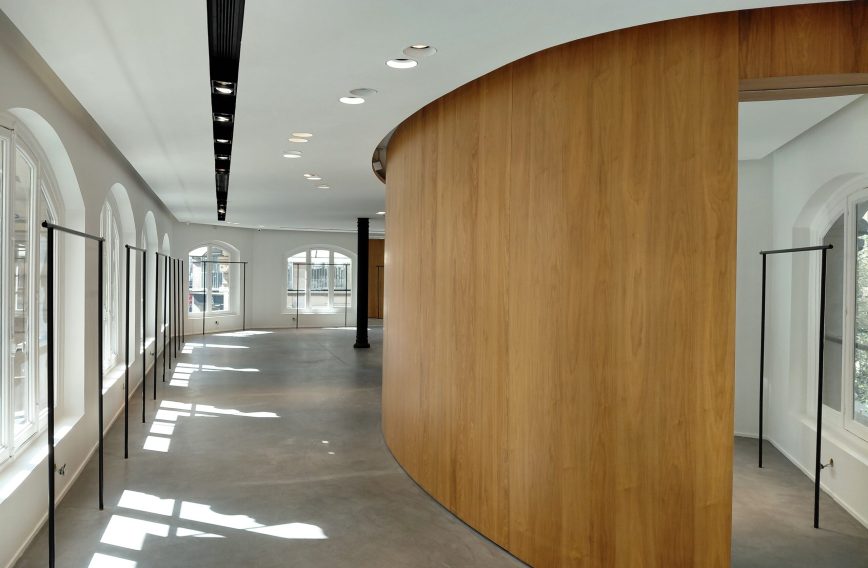 Curved wood pod along a glazed aisle on the first floor