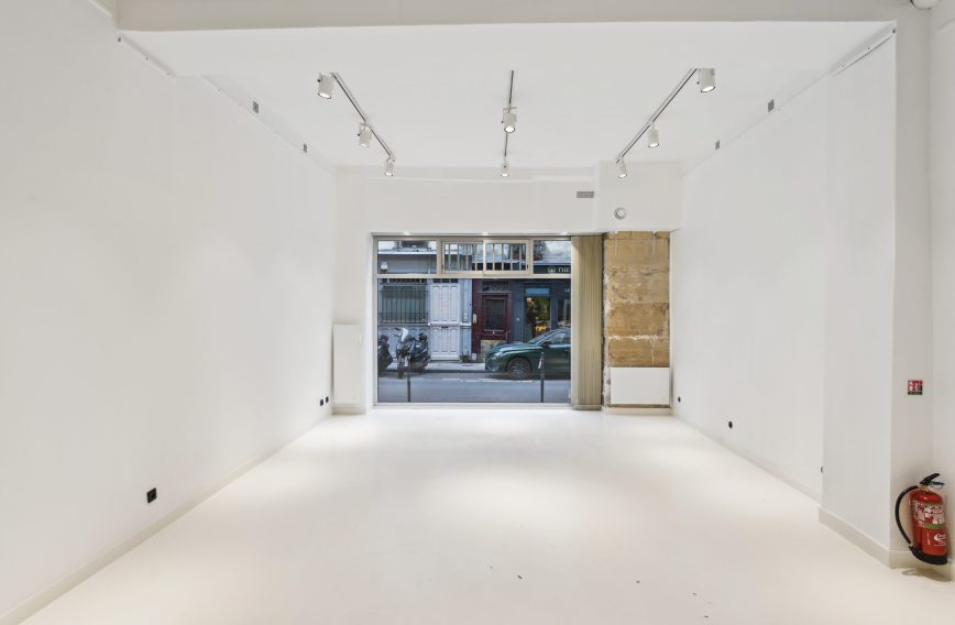 White-box interior with gallery track lighting and window to Rue Charlot — 52 Rue Charlot showroom