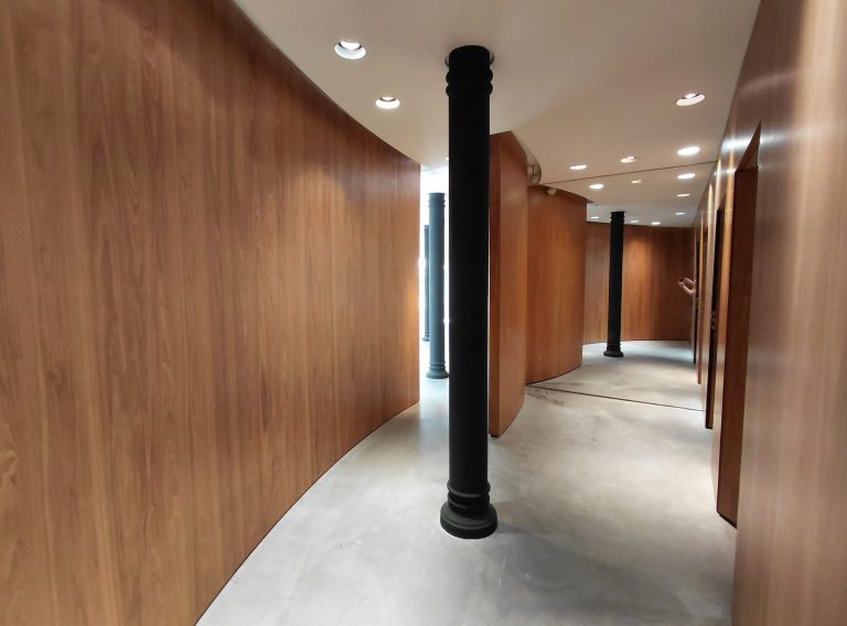 Curved wood corridor with cast-iron column, bright upper level