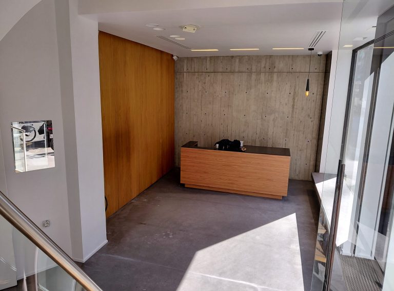 Curved wood counter with concrete wall, ground floor entry