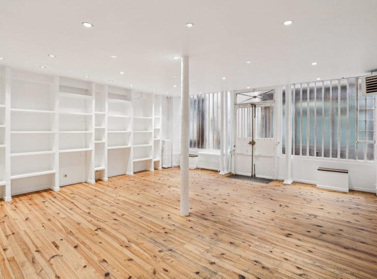 Ground floor showroom with shelving, column and track lighting, Paris Marais