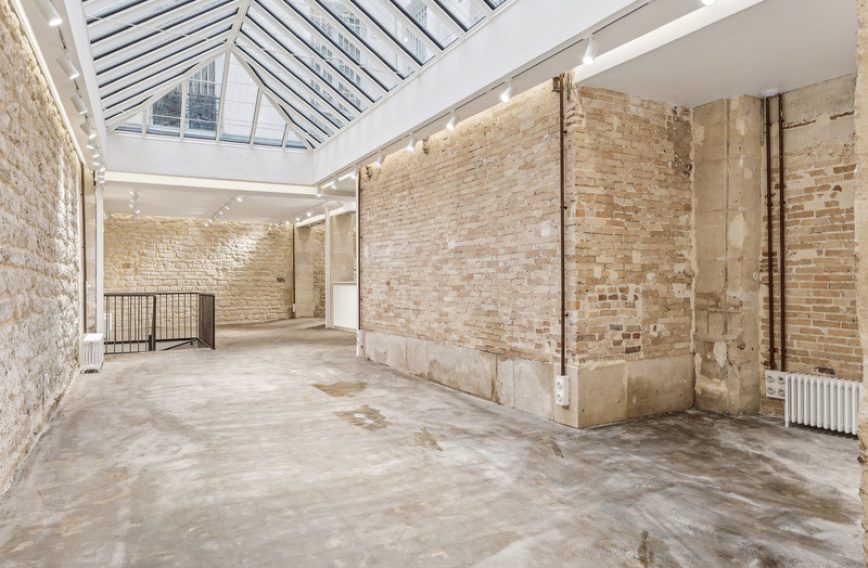Courtyard skylight and stone facade inside showroom — Rue du Sentier