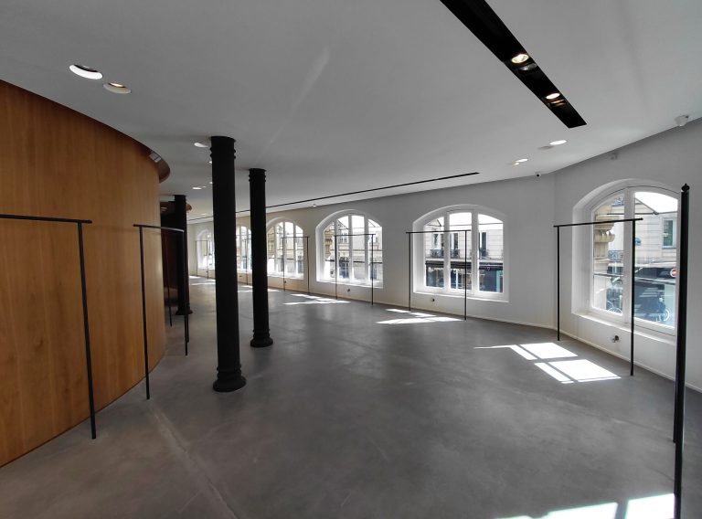 Large room with black columns, wood pod and wide windows