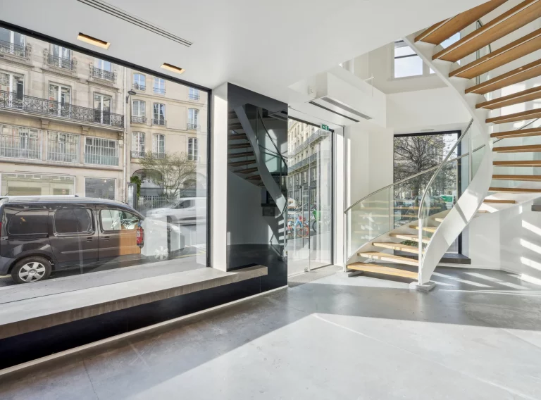 Ground-floor retail space with long shop window and open staircase to upper level.