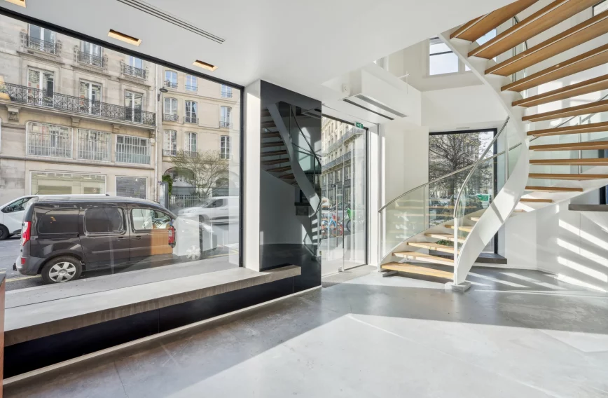 Ground-floor retail space with long shop window and open staircase to upper level.