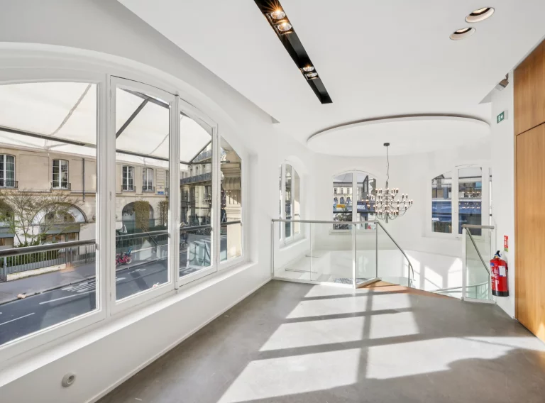 First-floor landing with arched windows, stair opening and wood wall on the right.