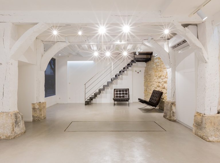 Seating corner by stair with stone wall — Haut Marais showroom