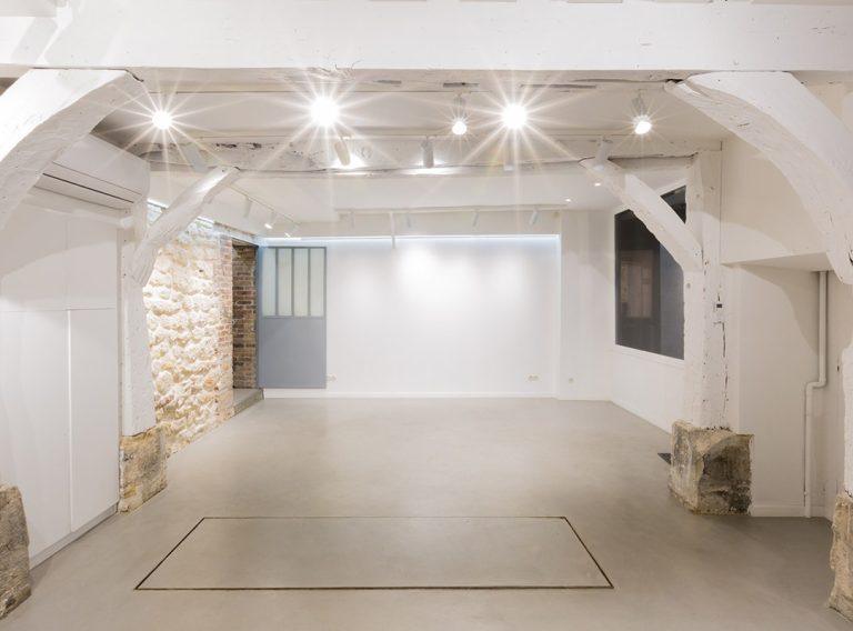 Centered view of white gallery with stone sides — Paris 3
