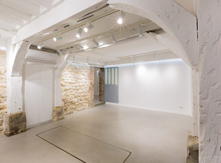 Exposed beams with adjustable track lighting — showroom Rue de la Corderie