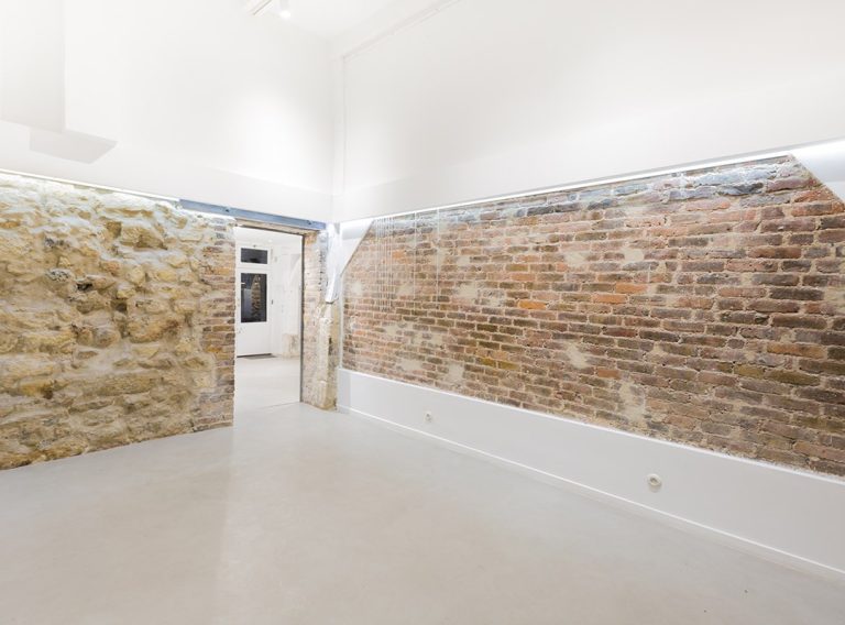 White gallery with exposed brick band — Showroom Futur-Corderies, Haut Marais